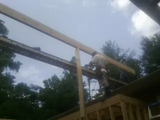 Carpenter setting a ridge beam over a new addition frame — Ice Dam Removal by Roofing Brothers in Palo Alto