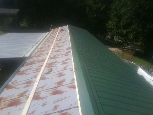Old rusted panels beside newly installed green metal roofing — Wind Damage Roof Repair by Roofing Brothers in Palo Alto