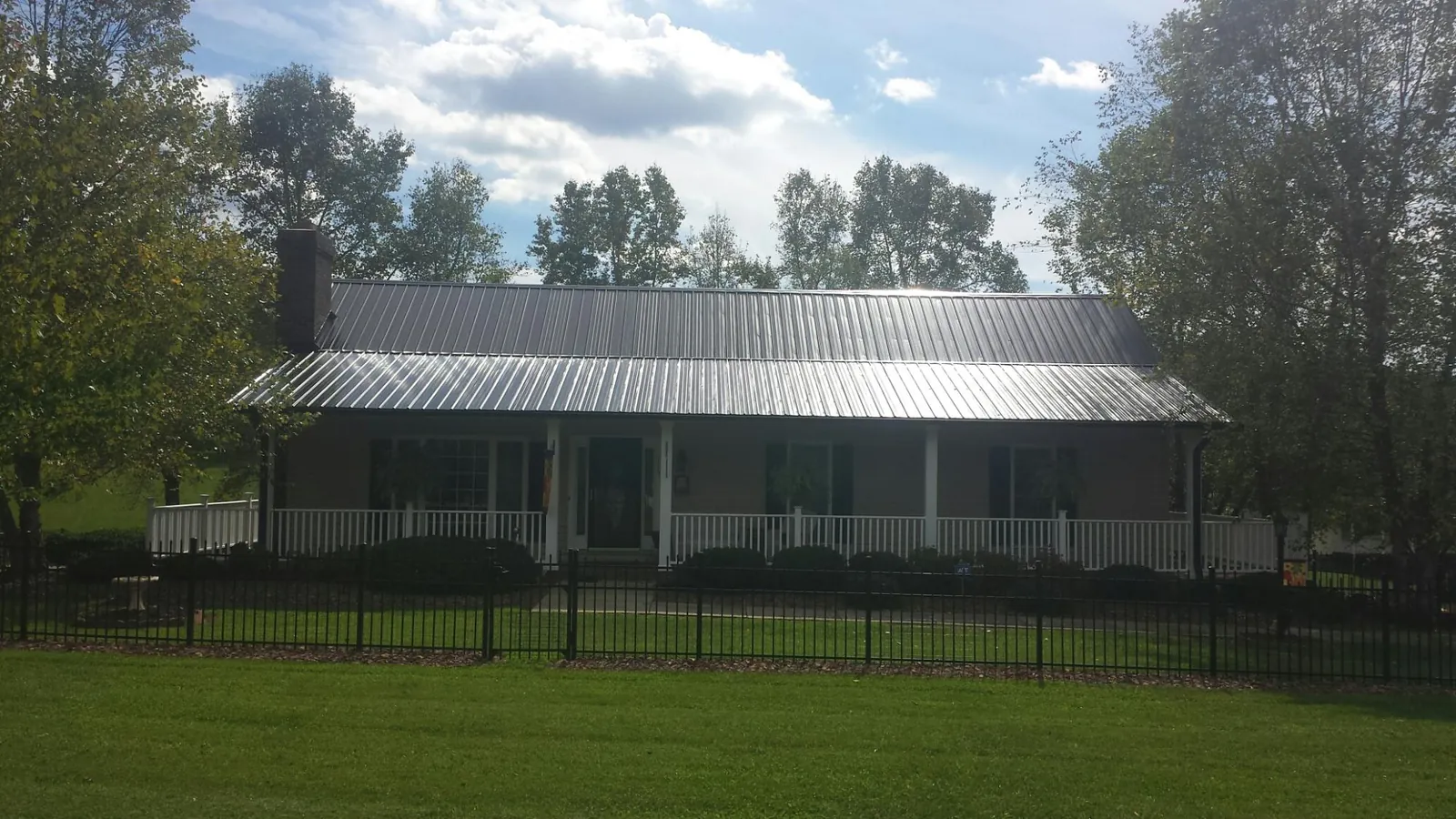 Gray metal roof on a brick ranch with a full width front porch — Gutter Guard Installation work by our crew in Palo Alto
