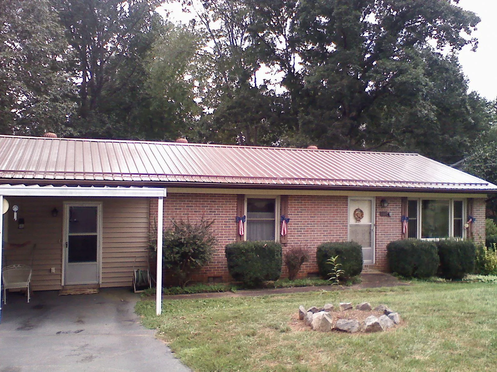 Bronze metal roof and carport on a brick ranch home — Roof Repair work by our crew in Palo Alto